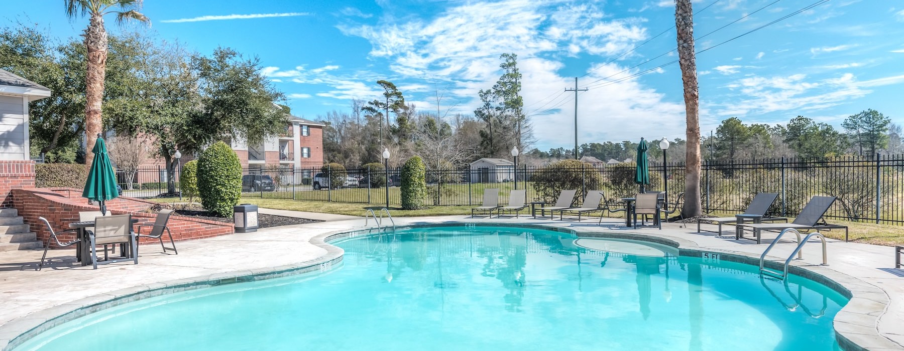 a pool with trees and houses in the background